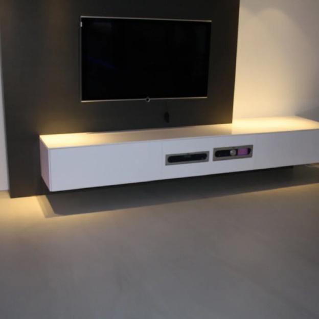 Stilvolle TV-Wand mit schwebendem weißen Lowboard und dezenter LED-Beleuchtung.