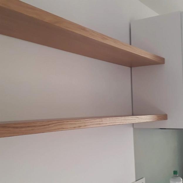 Zwei schlichte Wandregale aus Holz, elegant in einer modernen Küche integriert.