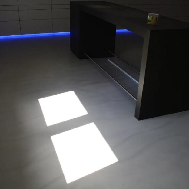 Schwarzer minimalistischer Tresen mit stilvoller LED-Beleuchtung im modernen Innenraum.