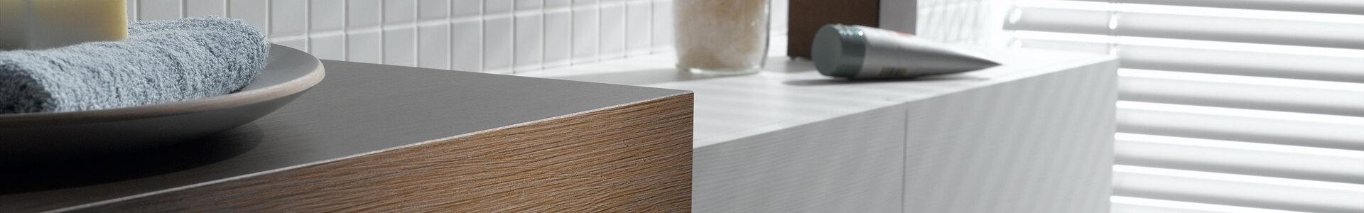 Detailaufnahme eines weißen Waschtischunterschrankes mit dunkler Waschtischplatte