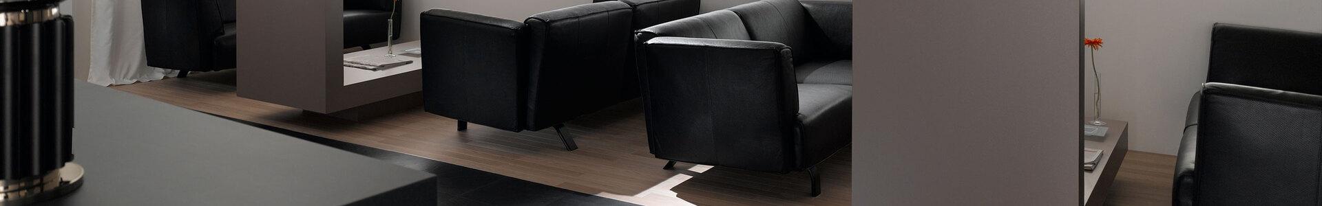 Hotellobby mit Trennwänden aus Holz Hotellobby mit Trennwänden aus Holz und schwarzen Ledersofas