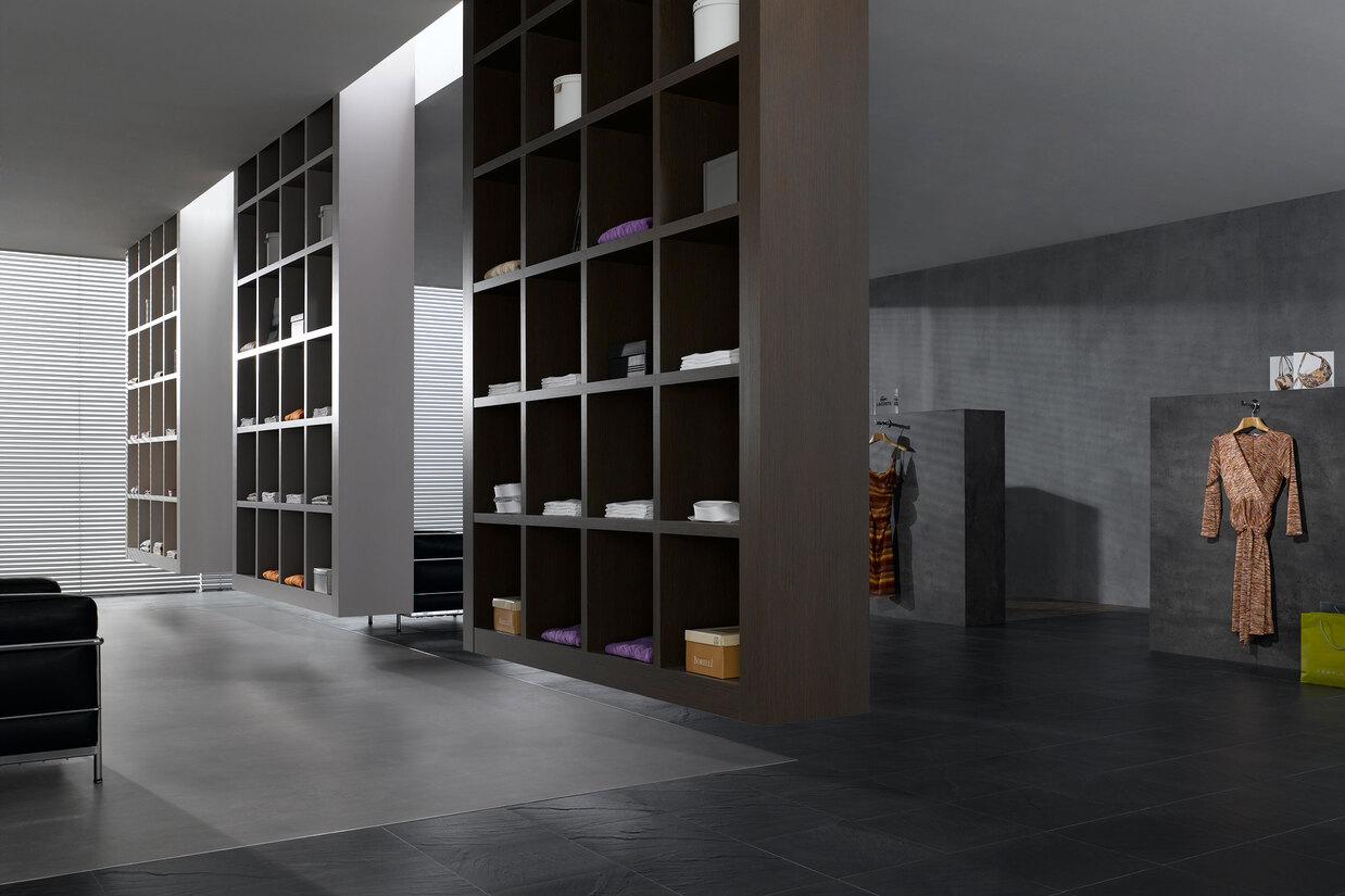 Impression eines geräumigen Regalsystems aus dunklem Holz in einem hochwertigen Bekleidungsladen