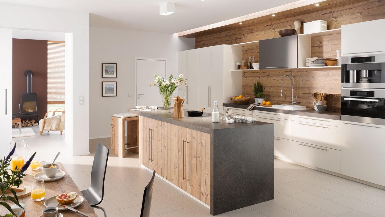 Impressionen einer Küche mit Esszimmer mit hellen Holzmöbeln und dunklen und weißen Fronten im Kontrast