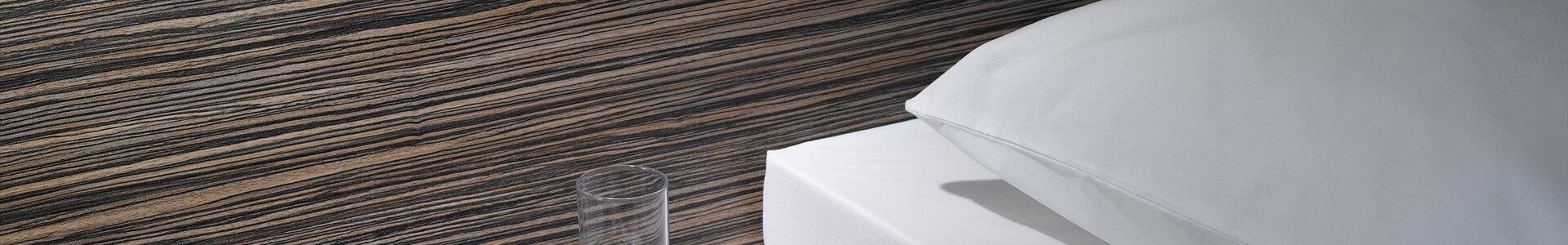 Detailaufnahme von Bettumrandung Detailaufnahme von Bettumrandung in dunklem Holz mit Ablagemöglichkeit