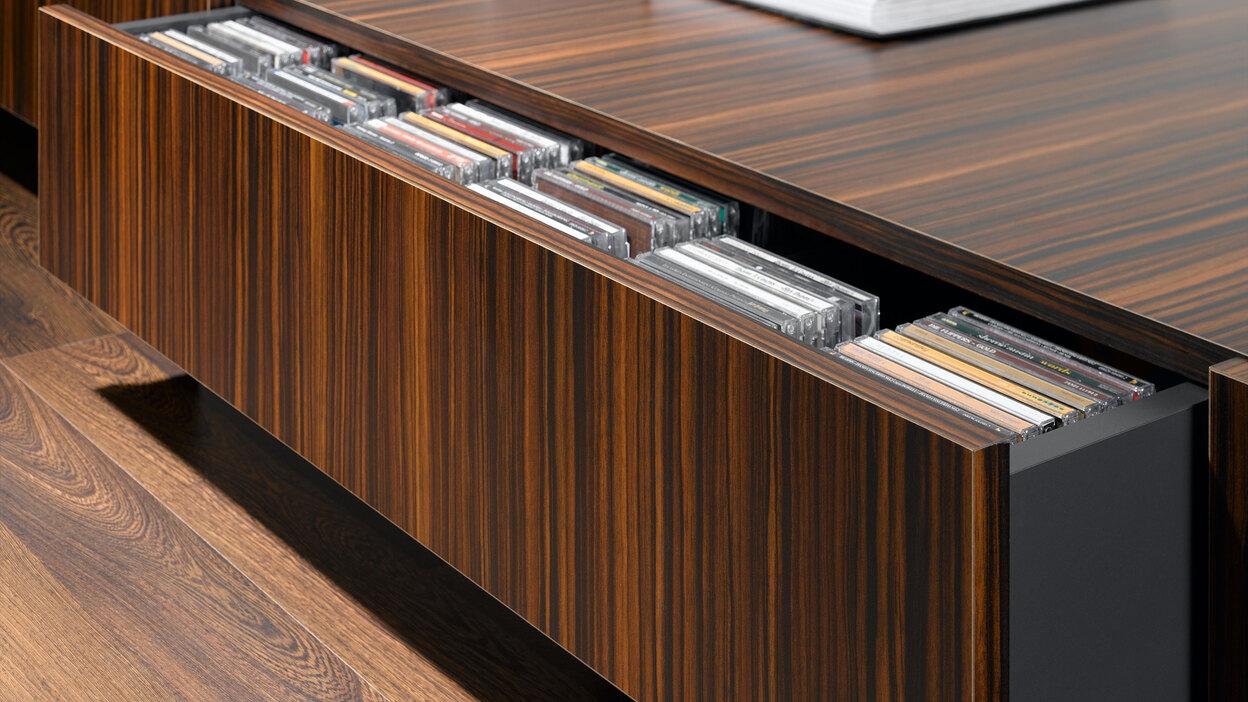 Detailaufnahme eines lackierten Sideboards mit offener Schublade für CD-Aufbewahrung